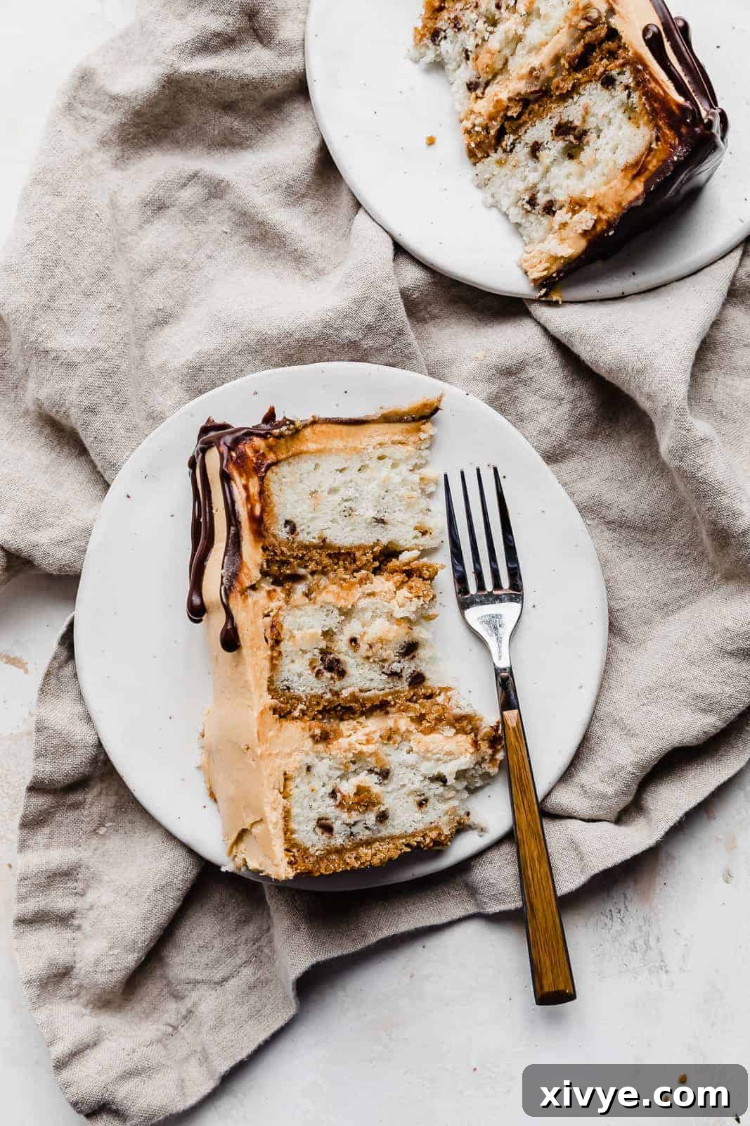 A perfectly sliced wedge of 7 Layer Bar Cake resting on a white plate, with a fork gently placed beside it, highlighting the intricate layers and inviting texture.