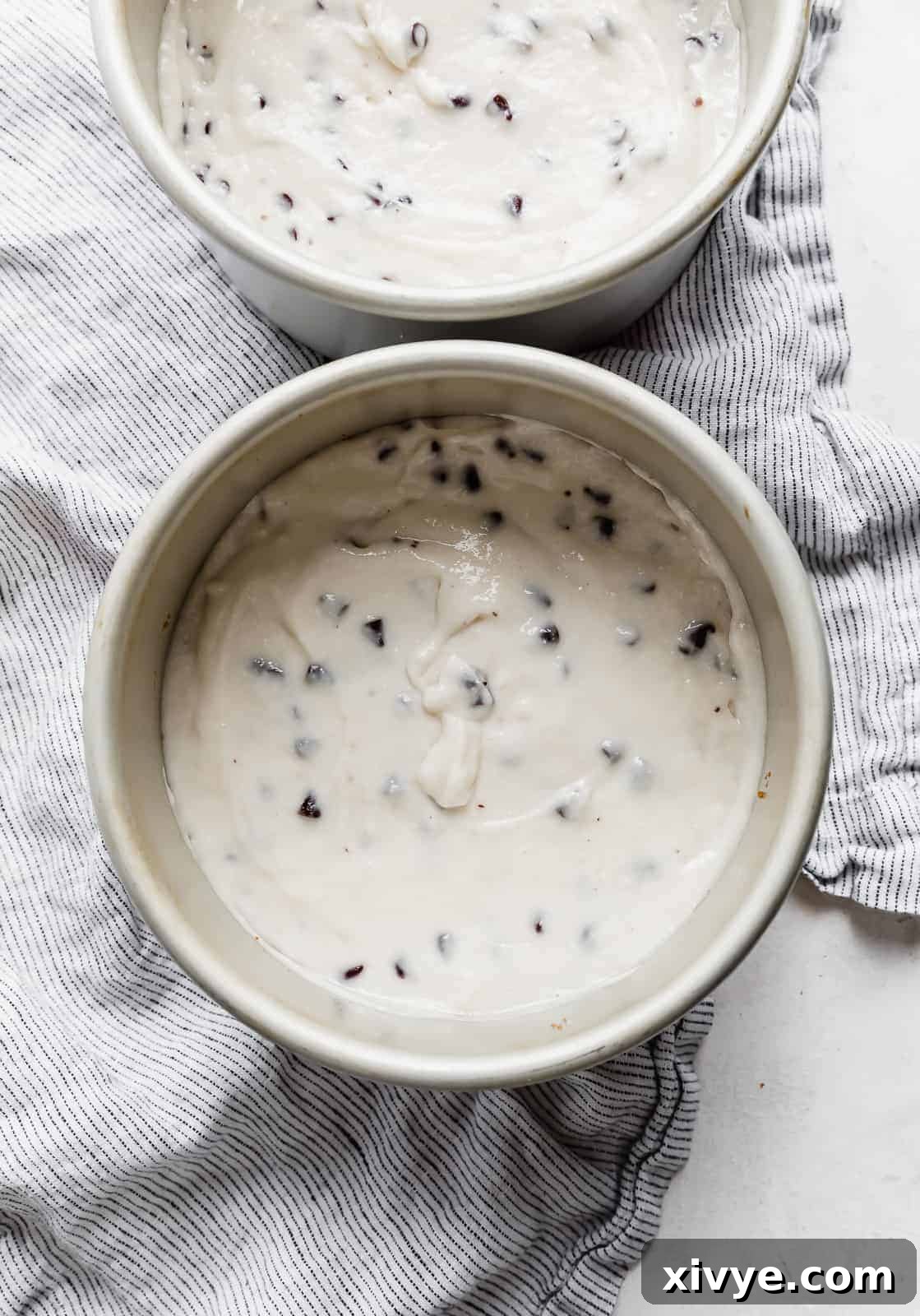 Smooth white cake batter flecked with mini chocolate chips, carefully poured over a graham cracker crust in a 6-inch round cake pan.