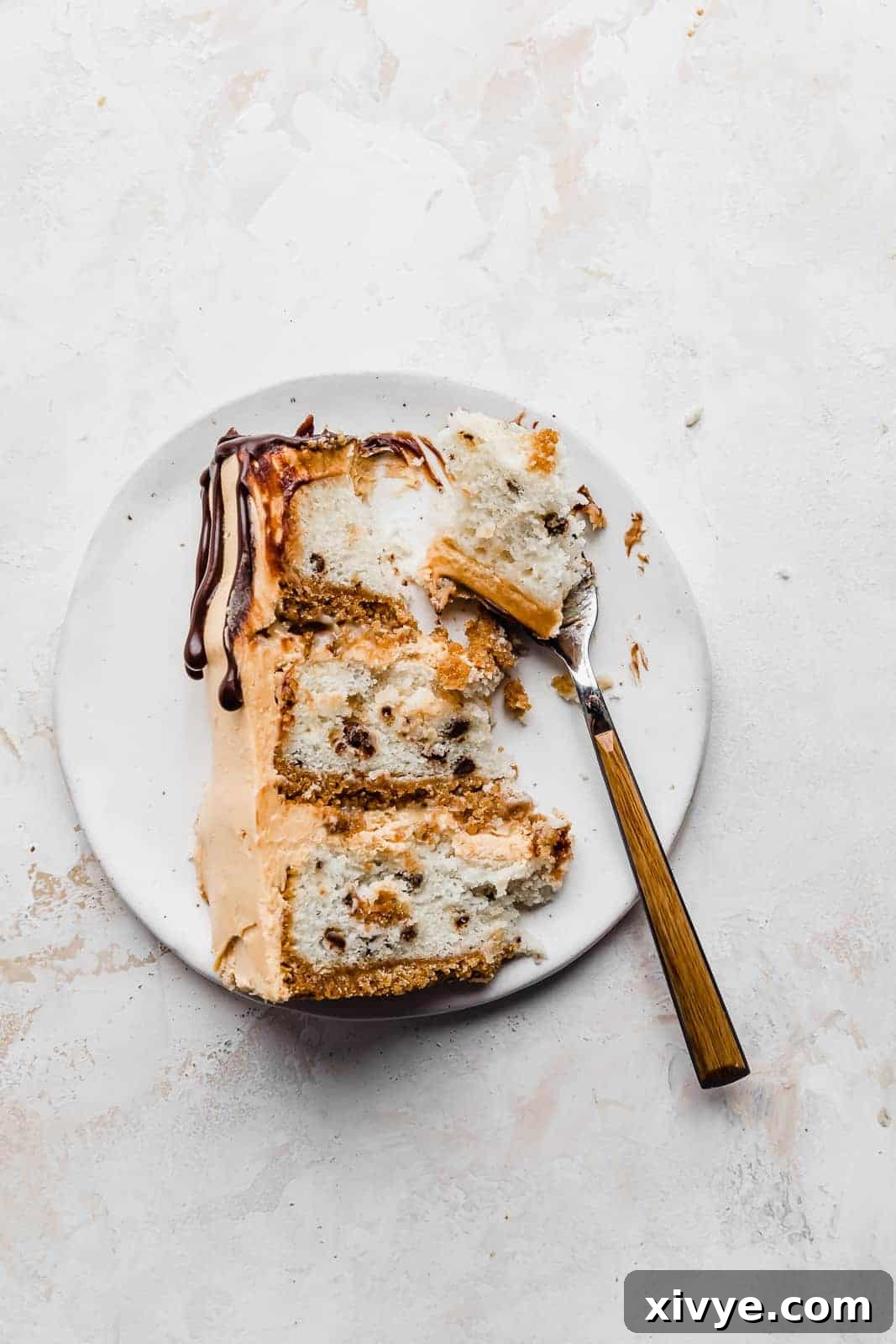 A fork poised to cut into a delectable slice of 7 Layer Bar Cake, highlighting its inviting layers and readiness to be savored.