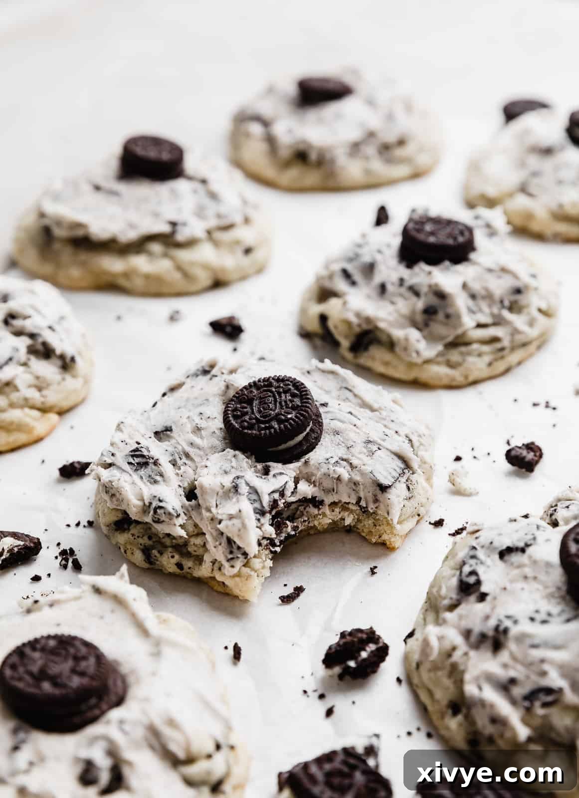 A copycat Crumbl Cookies and Cream Milkshake Cookie with a noticeable bite taken out, revealing its soft interior and chunks of Oreo.