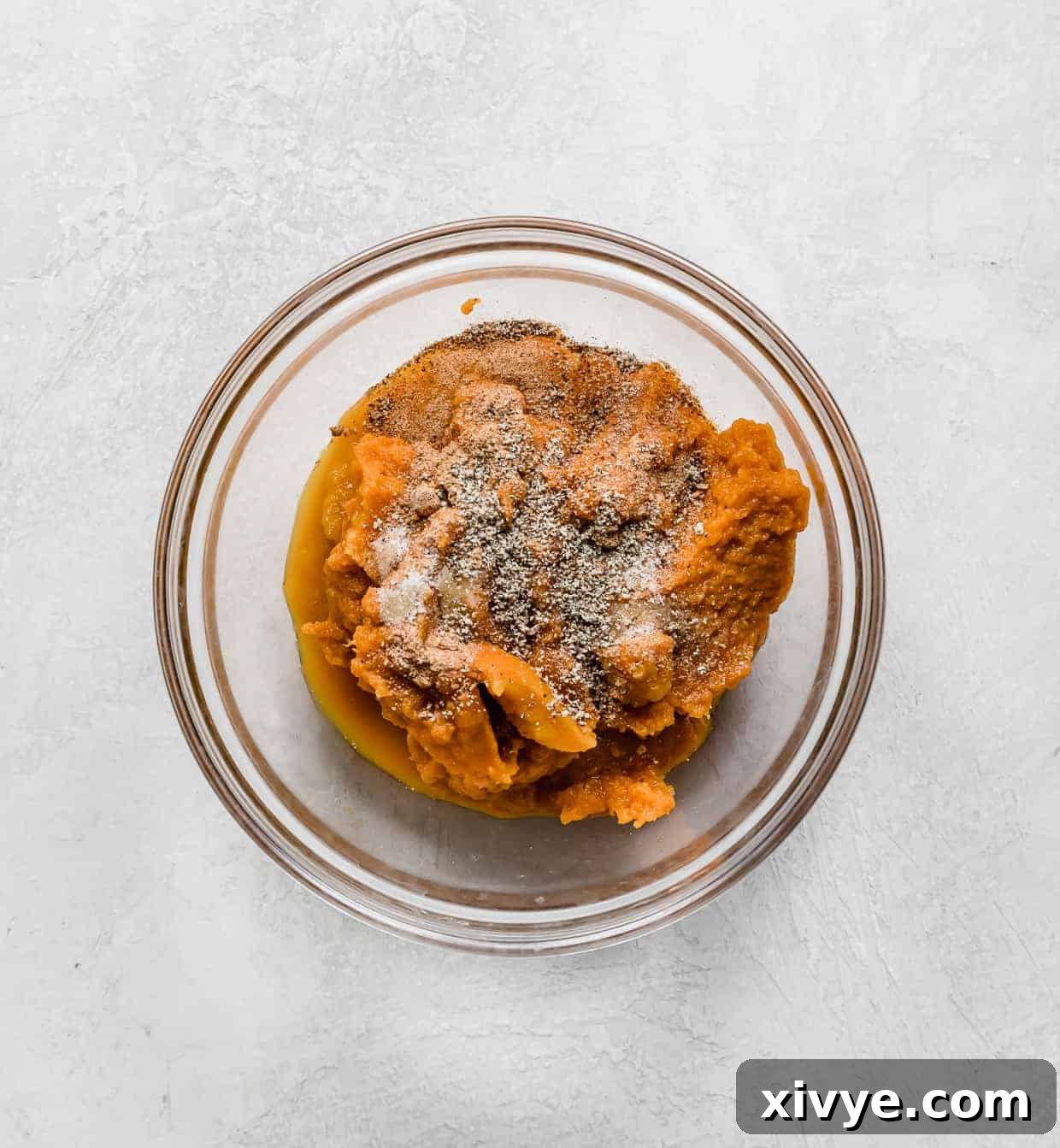 A glass bowl with pumpkin puree and spices.