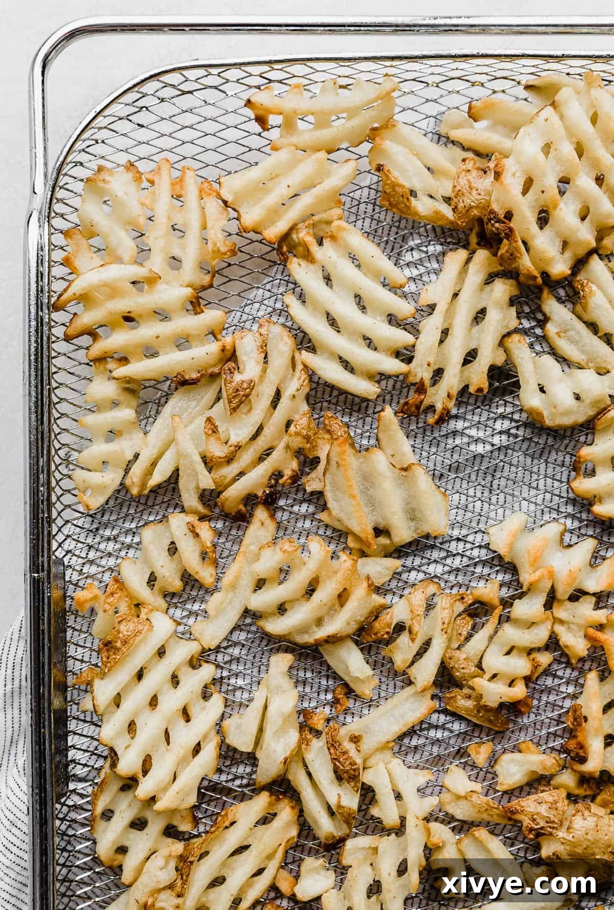 Crispy Waffle Fries from Your Air Fryer 6 Close-up of crispy air fryer waffle fries on a plate, ready to be seasoned.