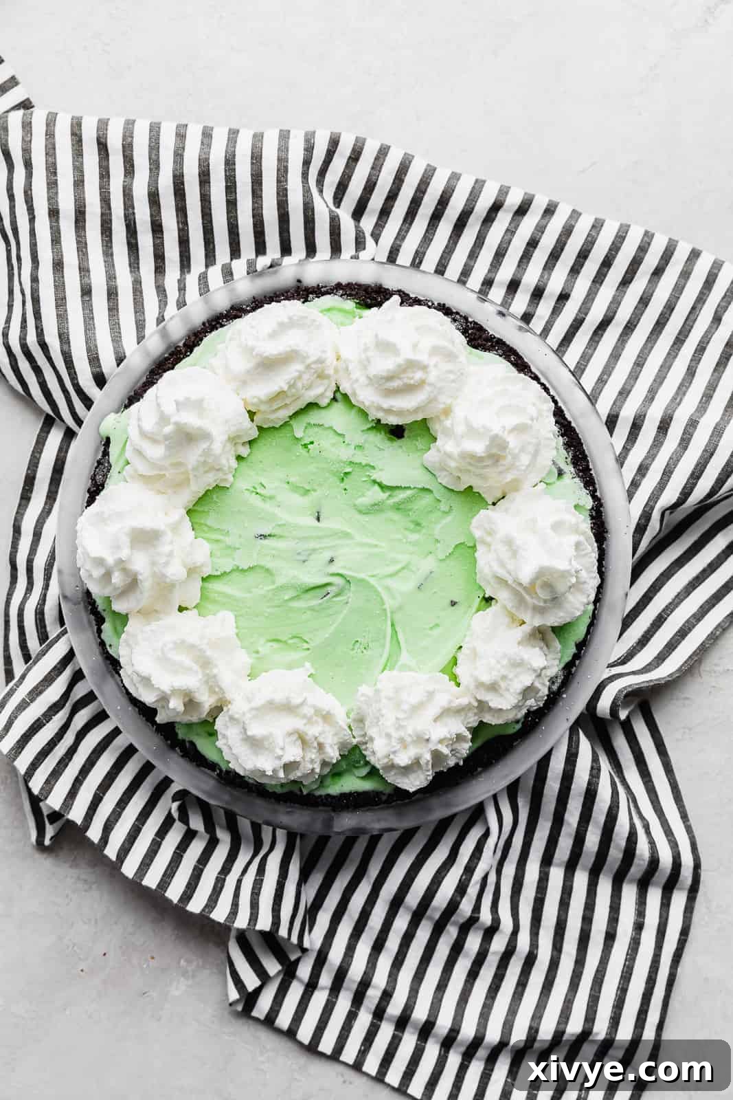 Concrete Crumble 5 An Asphalt Pie beautifully topped with fluffy whipped cream piped along its edges, ready for caramel and crushed Oreos.