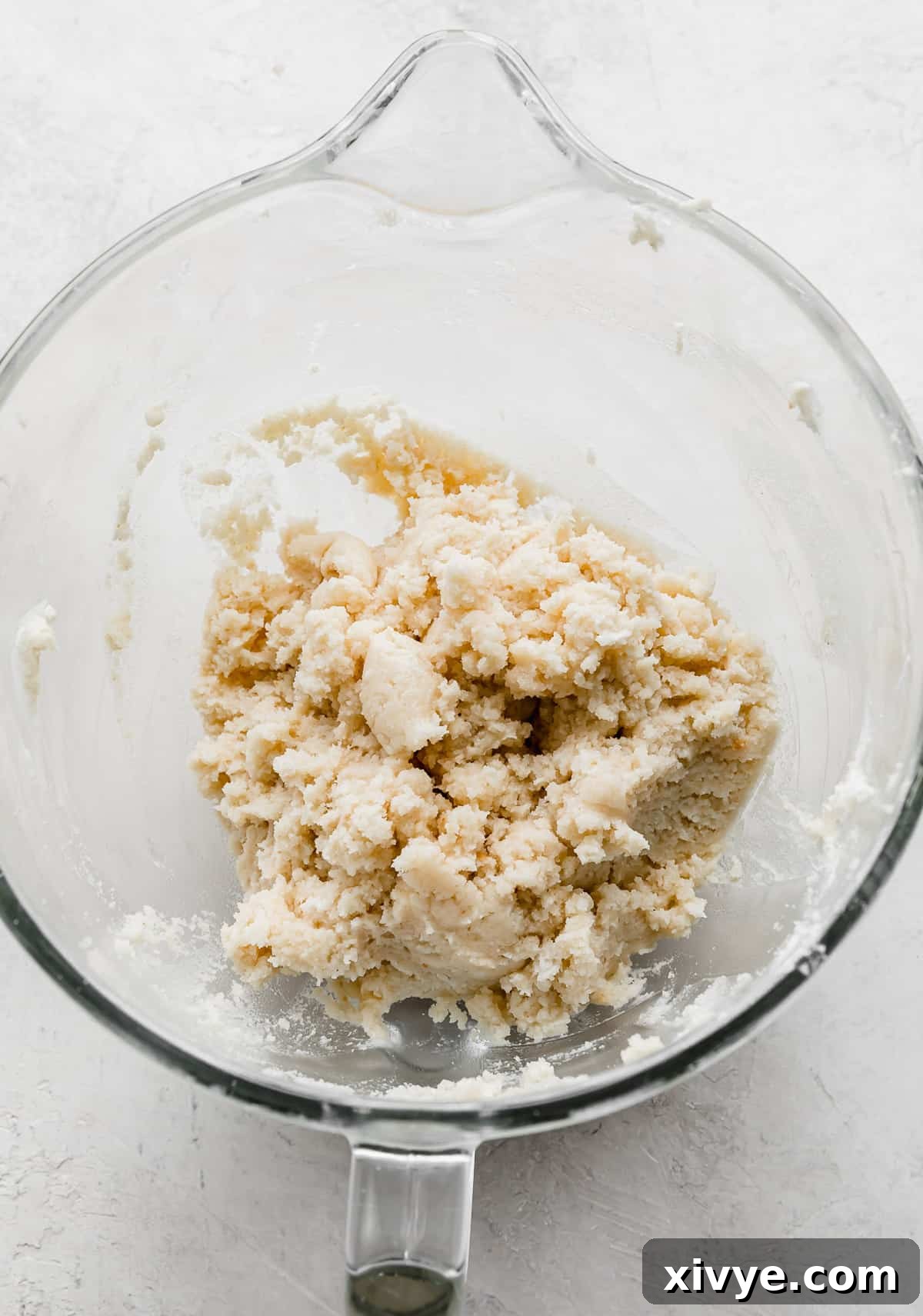 Delightful Cake Lollies 6 A clear glass mixing bowl holding the combined ingredients for cakesicles, a perfect blend of cake and frosting.