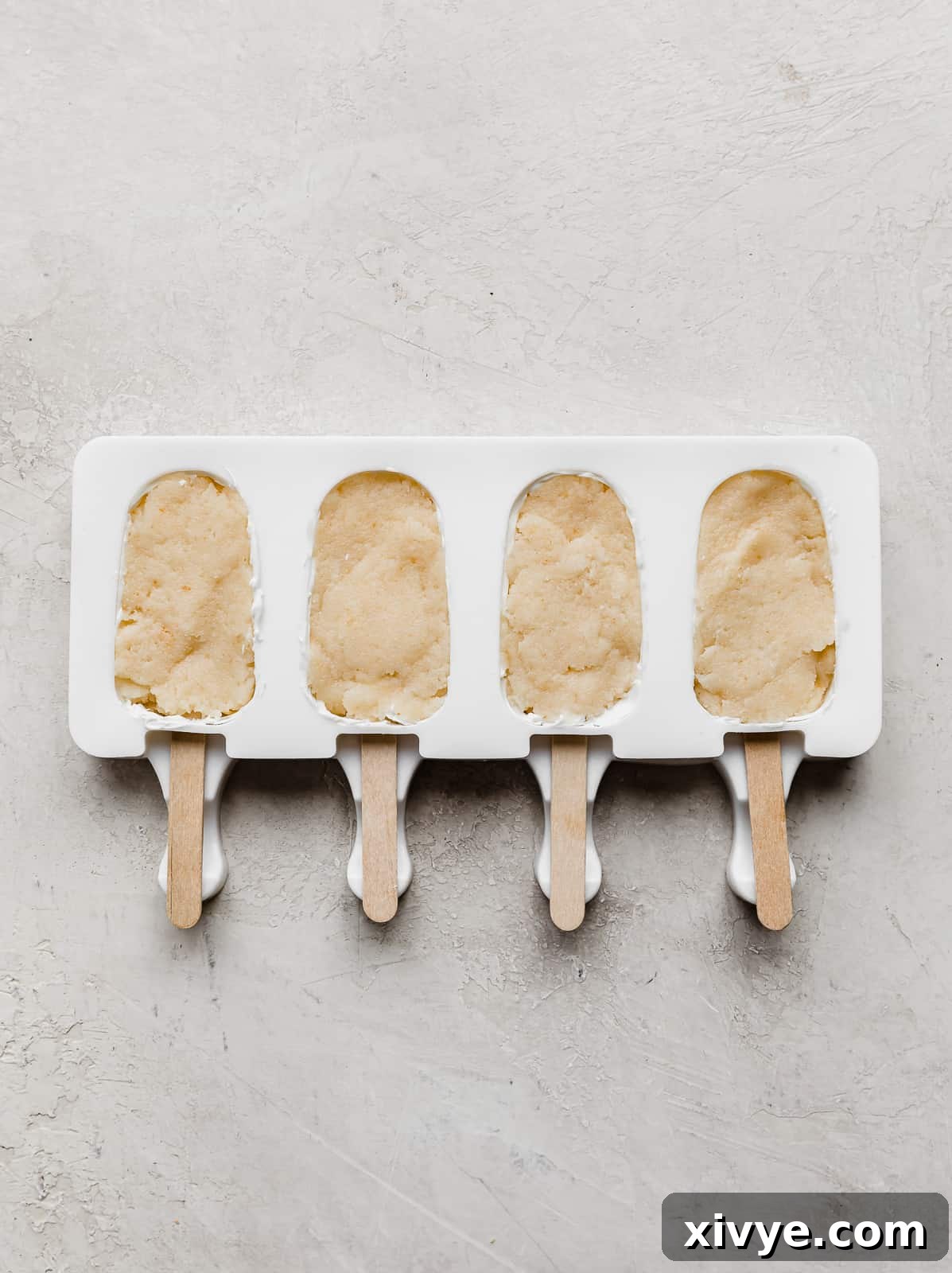 Delightful Cake Lollies 8 A white cakesicle mold, each cavity expertly pressed with a delightful mixture of cake and frosting.