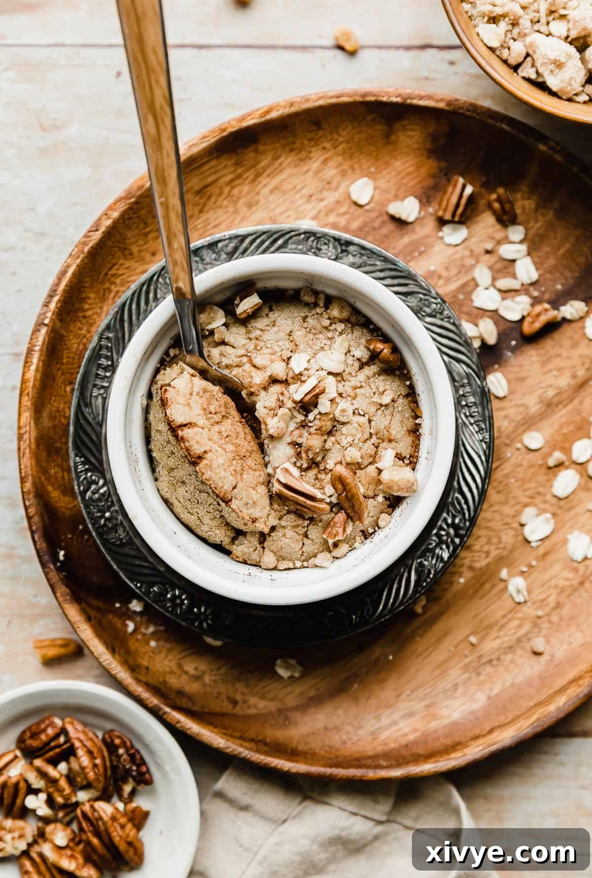 A white ramekin with a single serving of Baked Oats Recipe in it, looking fluffy and golden brown.