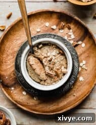 A ramekin with Baked Oats in it on a round wooden plate, ready for serving.