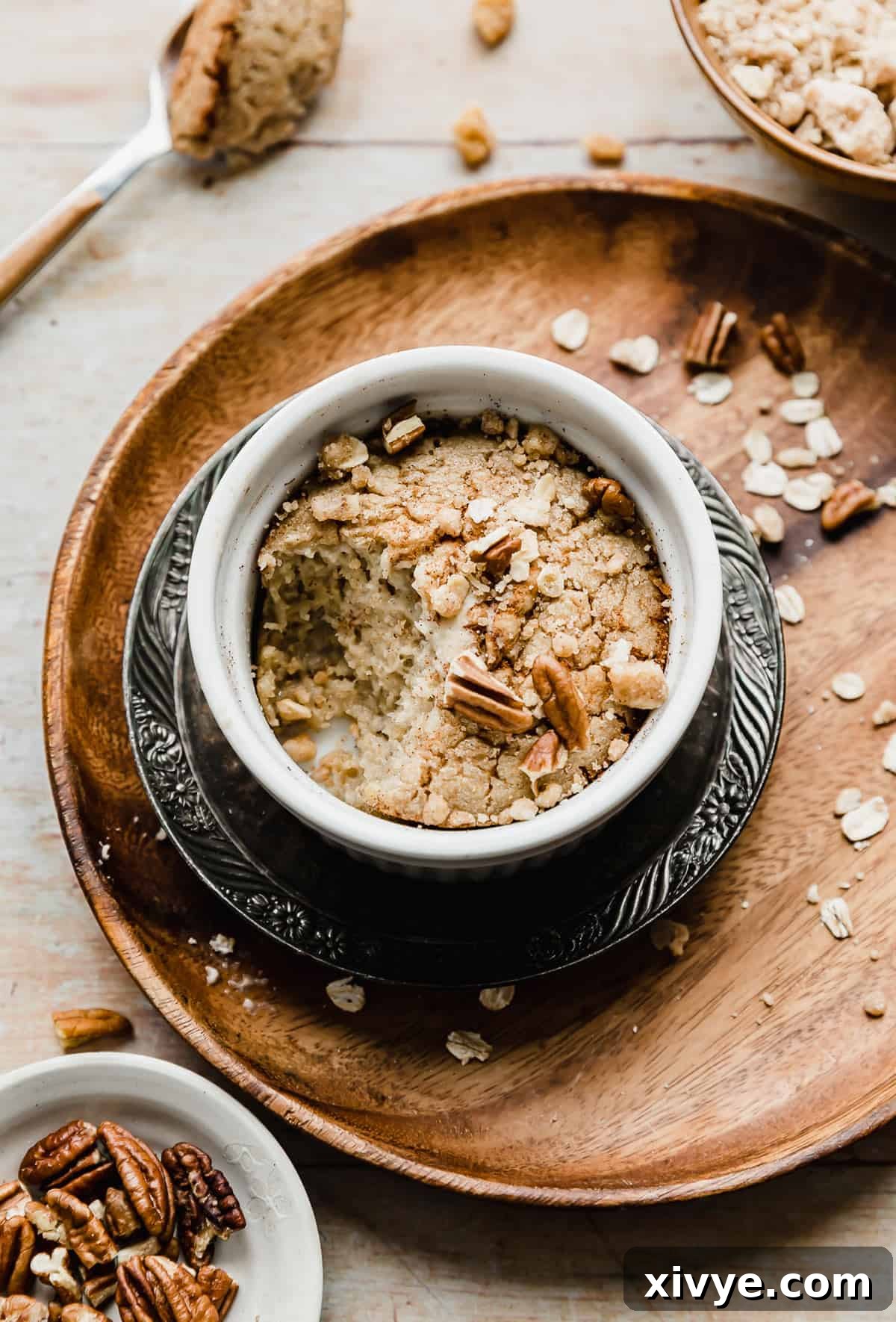 A Baked Oats Recipe in a ramekin with a large scoopful taken out of it, showing its fluffy texture.