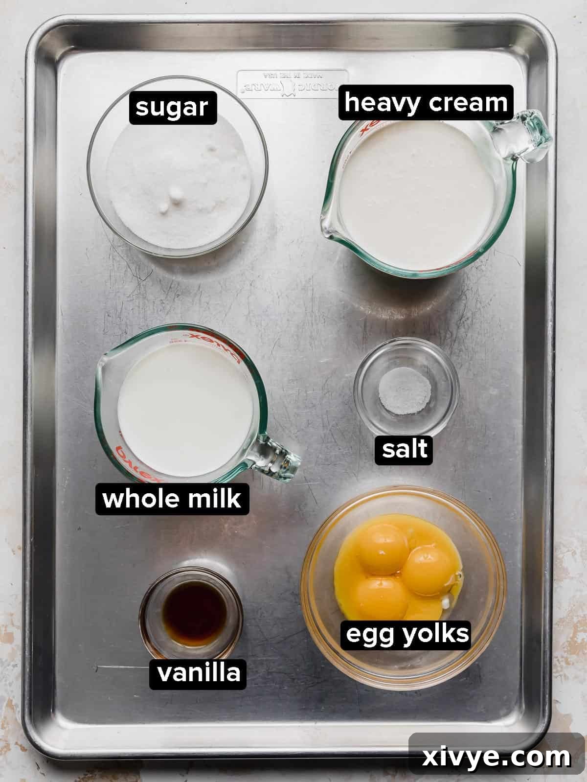 Homemade Vanilla Ice Cream ingredients portioned into glass bowls, on a silver baking sheet.