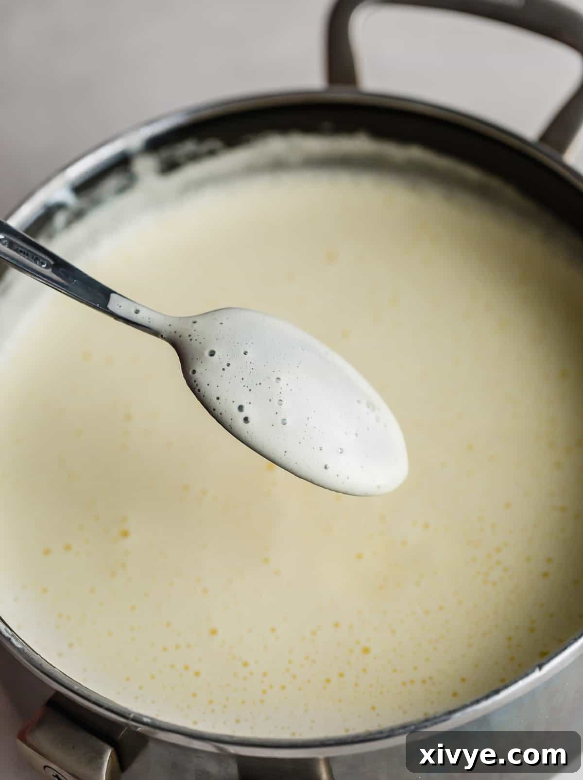 A light yellow vanilla ice cream mixture coating the back of a spoon.