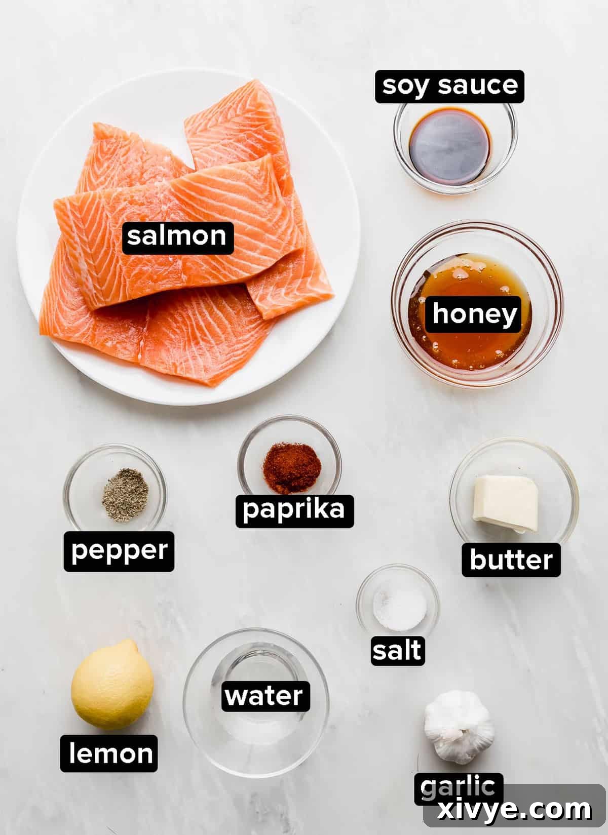 Sticky Honey Garlic Salmon 3 Honey Garlic Baked Salmon ingredients in small glass bowls on a light gray background, ready for preparation.
