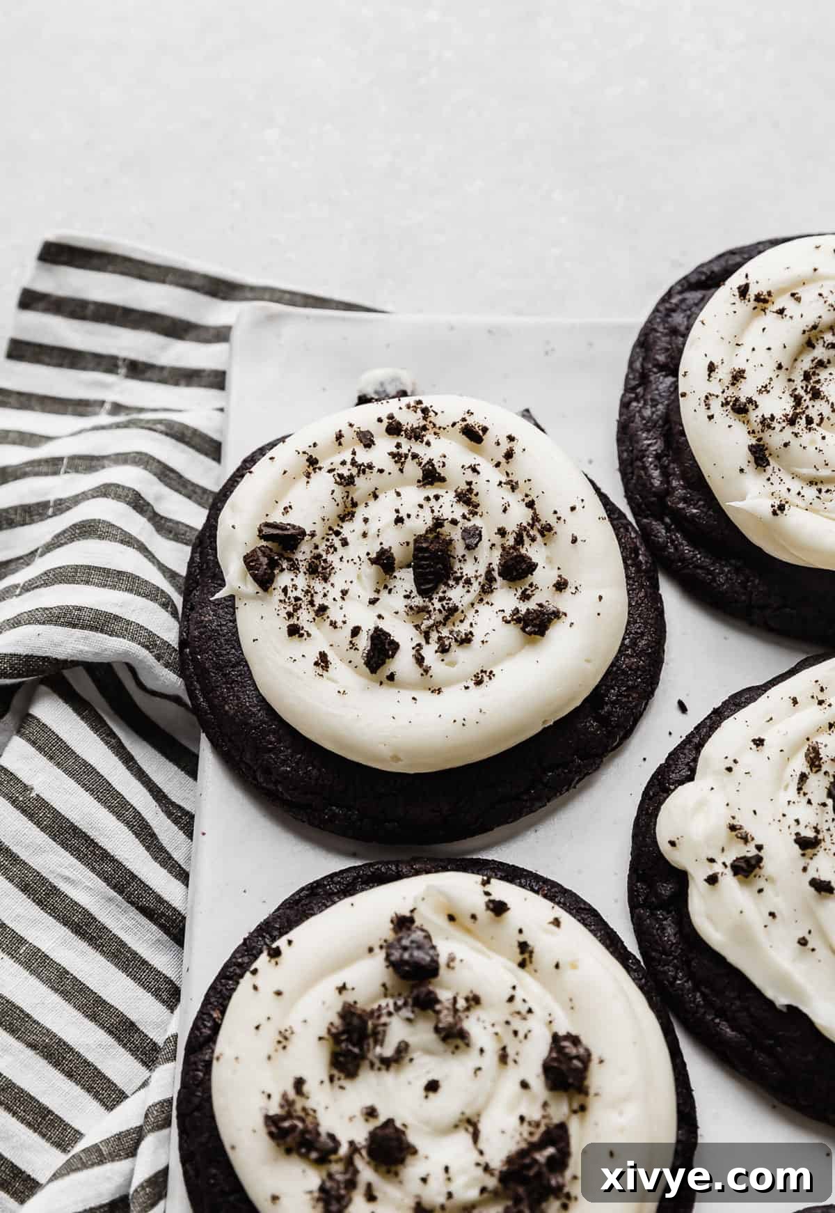 Giant Crumbl Style Chocolate Oreo Cookies 2 A black cookie topped with cream cheese frosting and crushed Oreos.