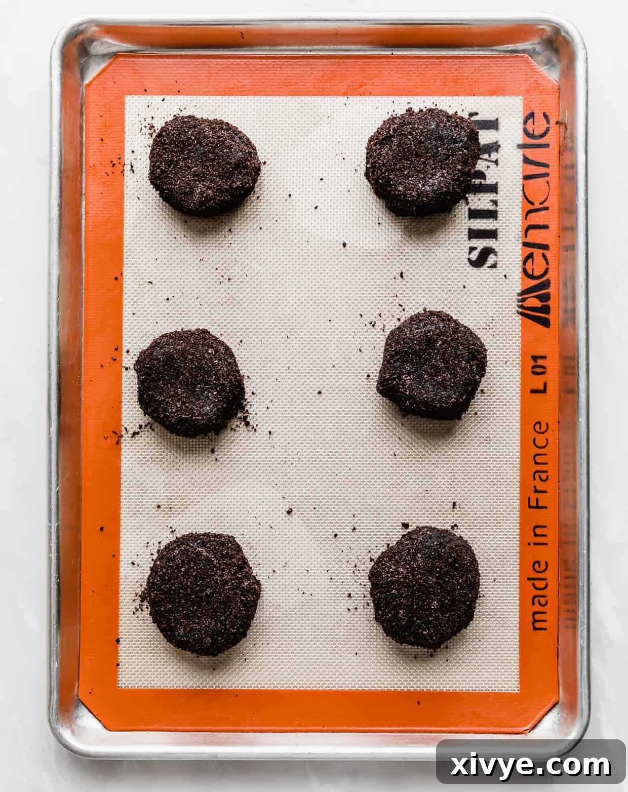 Giant Crumbl Style Chocolate Oreo Cookies 11 Six Crumbl Chocolate Oreo Cookie dough balls on a baking sheet.