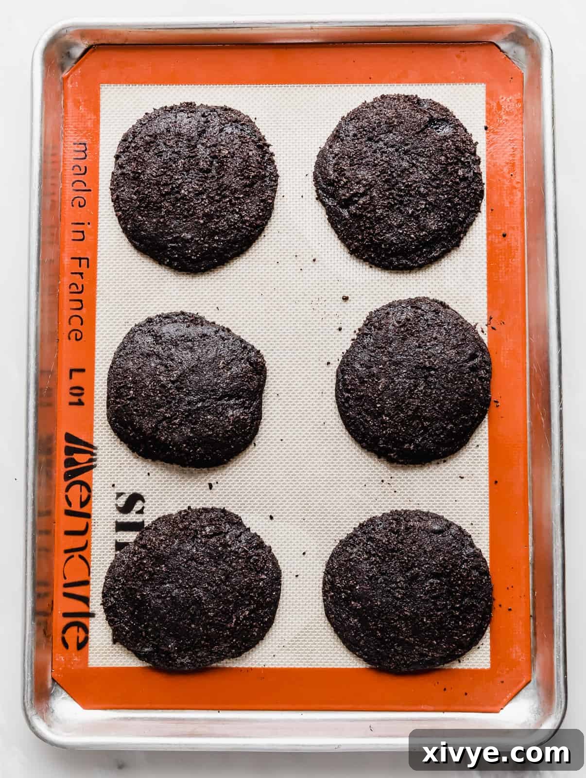 Giant Crumbl Style Chocolate Oreo Cookies 12 Six Crumbl Chocolate Oreo Cookies on a baking sheet.