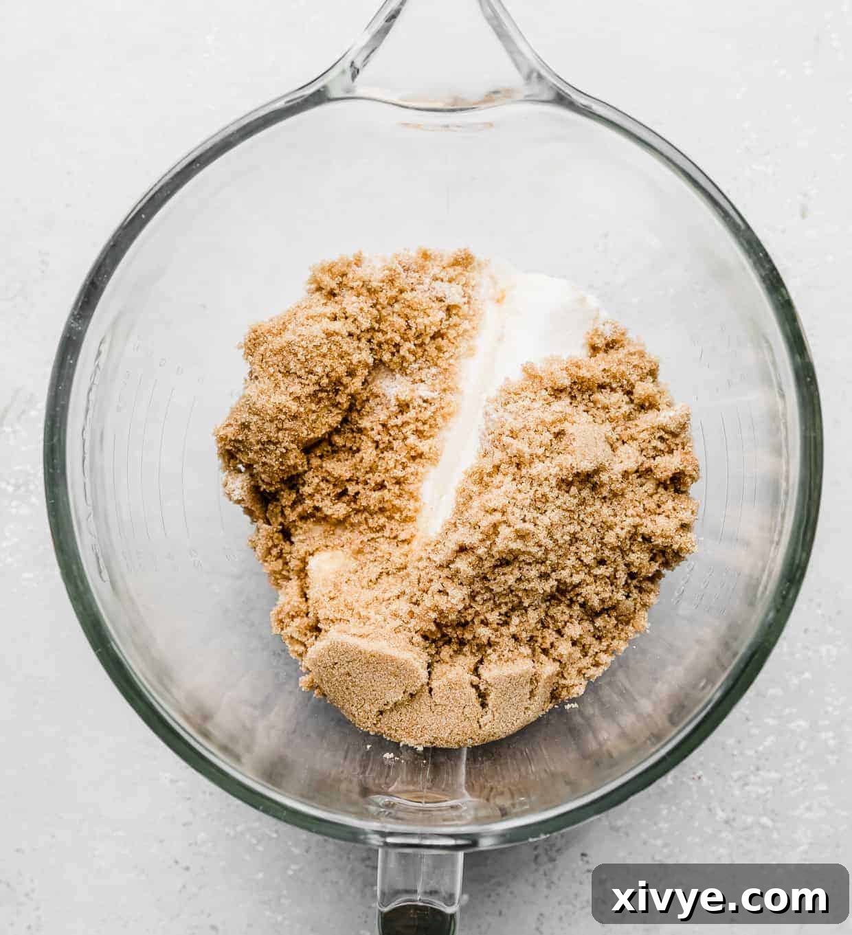 Giant Crumbl Style Chocolate Oreo Cookies 5 A glass mixing bowl with brown sugar, sugar, and butter in it.