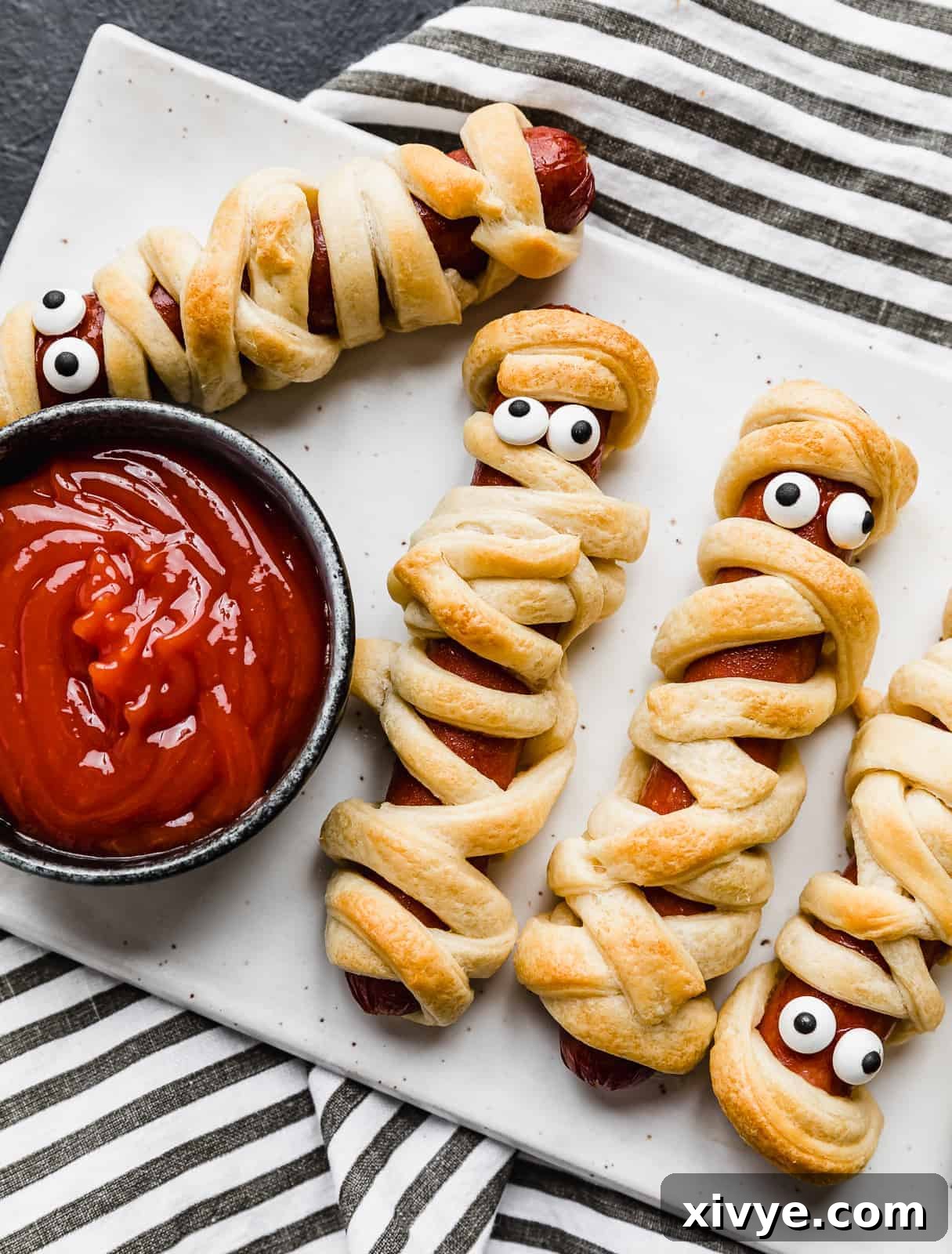 Creepy Canine Wraps 2 A hot dog wrapped in crescent roll strips.