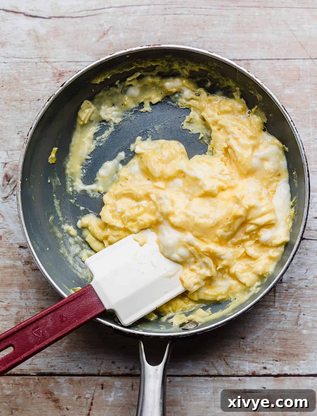 Scrambled Eggs in a gray skillet.