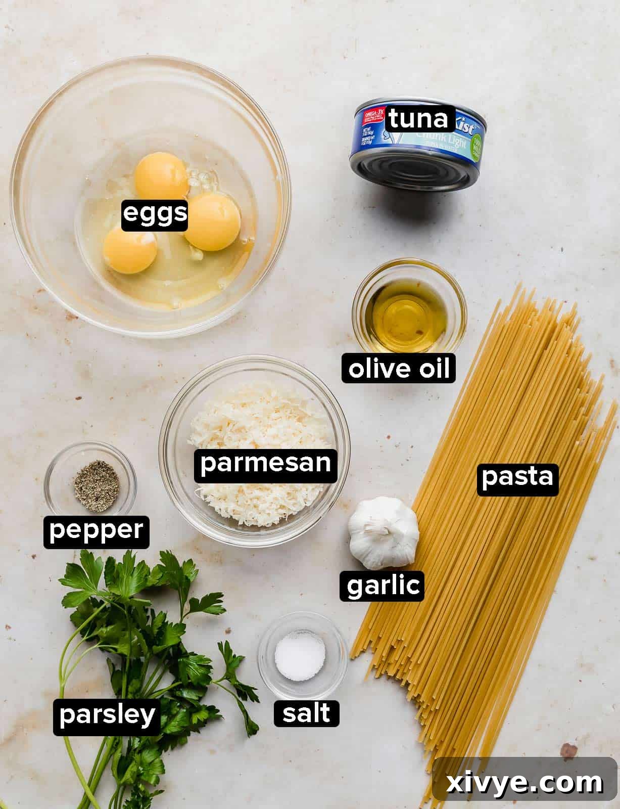Ingredients used to make Tuna Carbonara on a white background. 