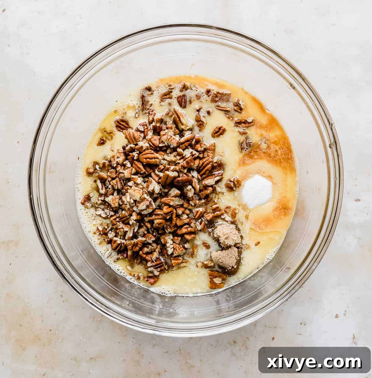 Ultimate Southern Pecan Pie 4 A glass bowl with ingredients to make pecan pie.