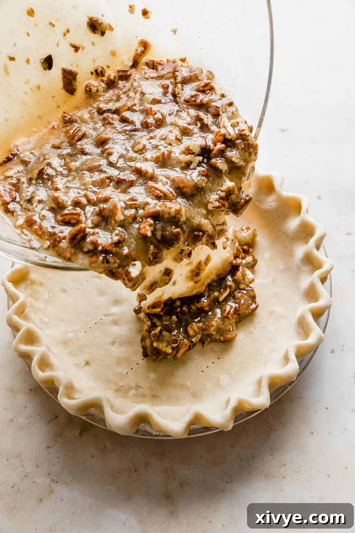 Ultimate Southern Pecan Pie 6 Pecan pie mixture being poured into an unbaked pie crust.