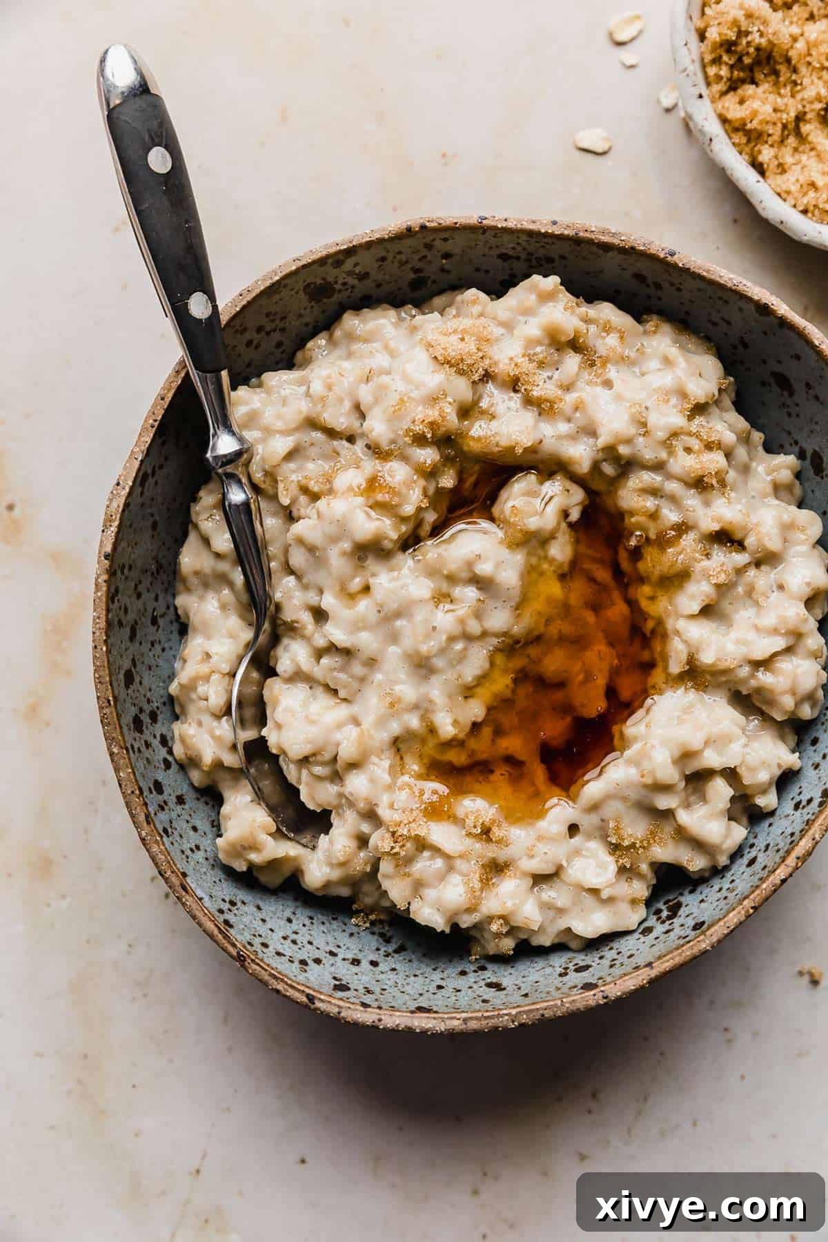 Golden Maple Oat Sweetness 6 Maple syrup overtop a batch of Maple and Brown Sugar Oatmeal in a bowl.