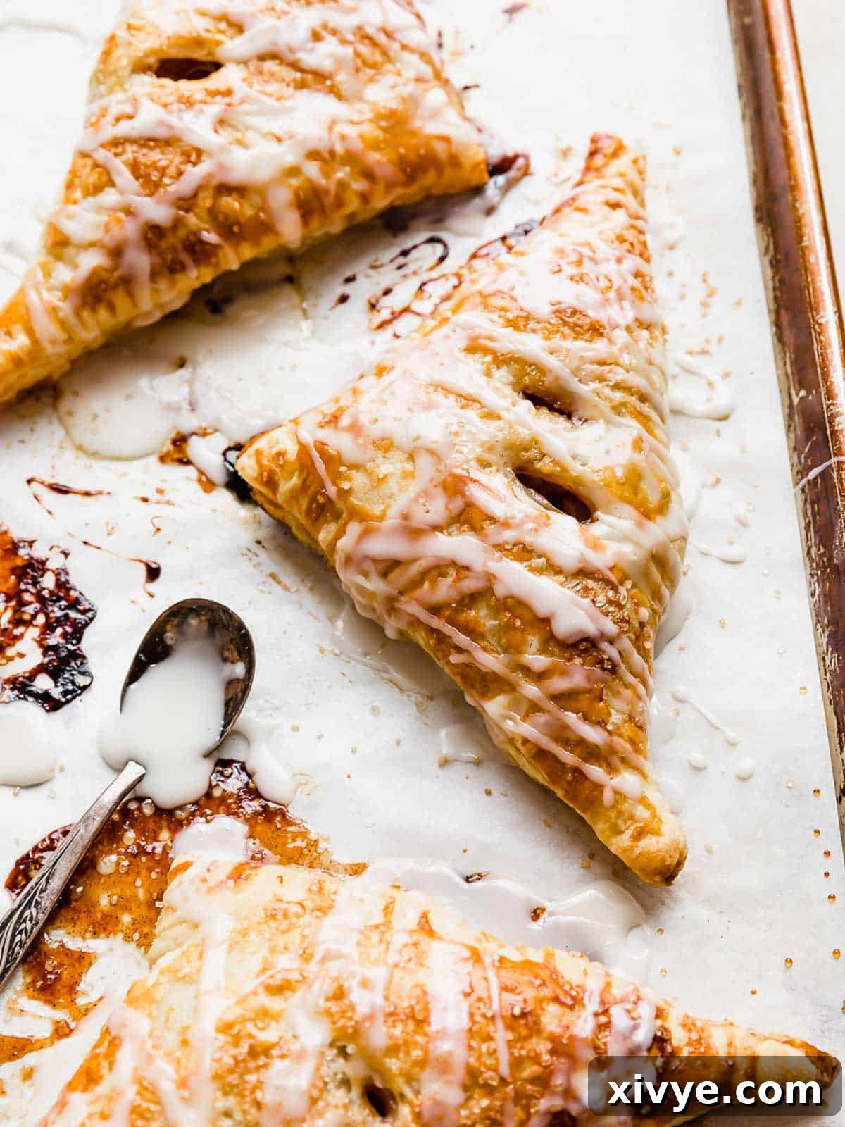 Puff Pastry Apple Turnovers on a white parchment lined baking sheet.
