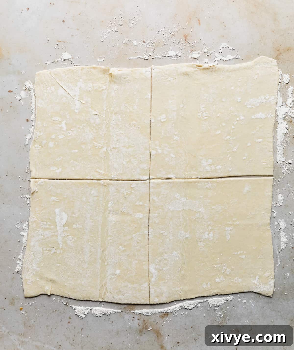 A square of puff pastry cut into 4 equal squares.