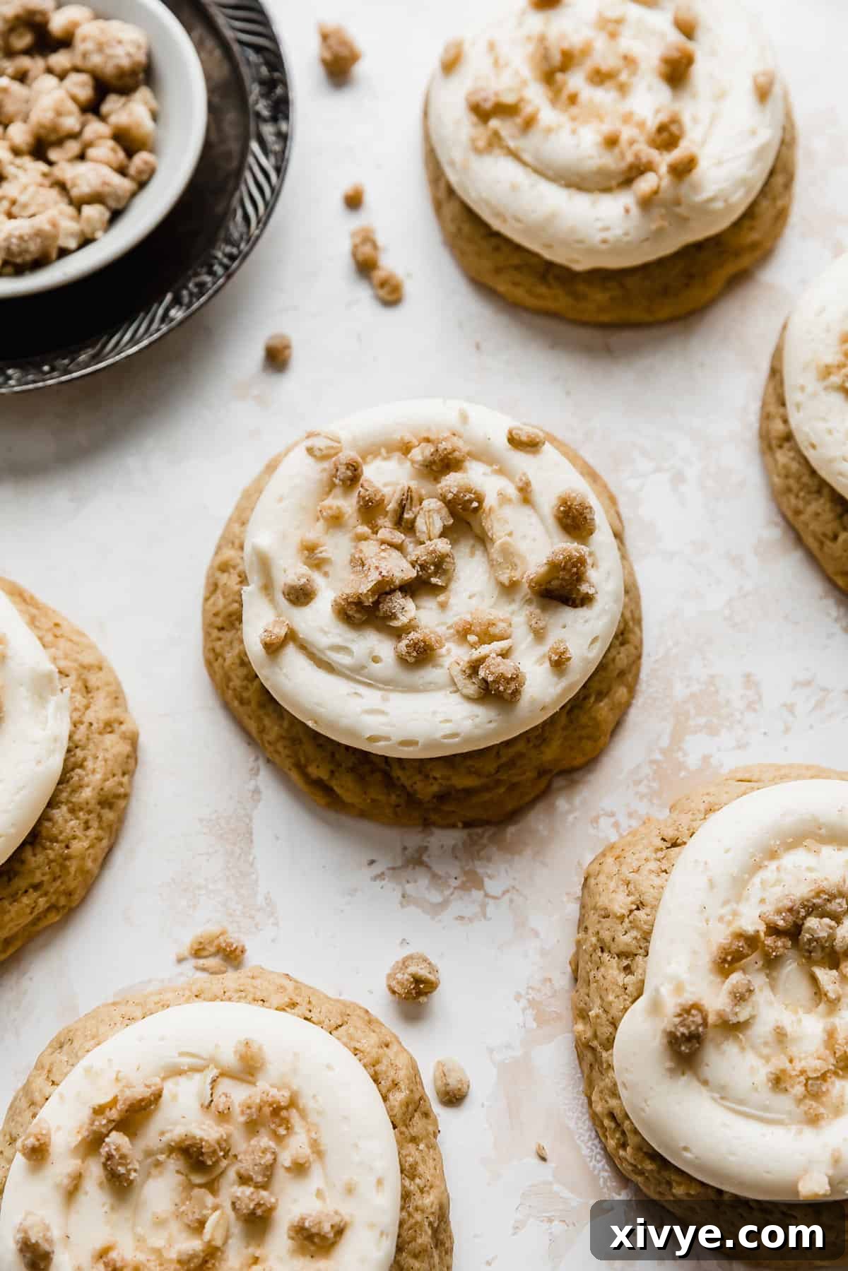 Gooey Caramel Apple Cookies 2 A caramel apple cookie topped with a homemade streusel topping on a textured cream background.