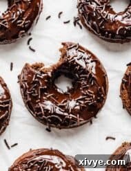 Chocolate Doughnuts on a white background with a bite taken out of it.