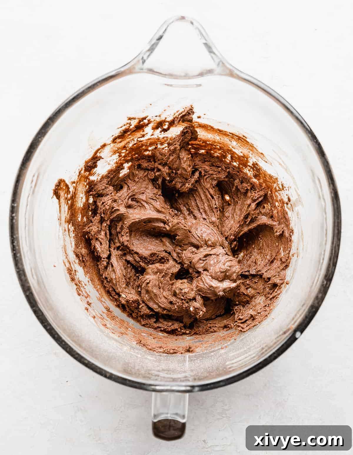 Chocolate Doughnut batter in a glass stand mixer bowl.