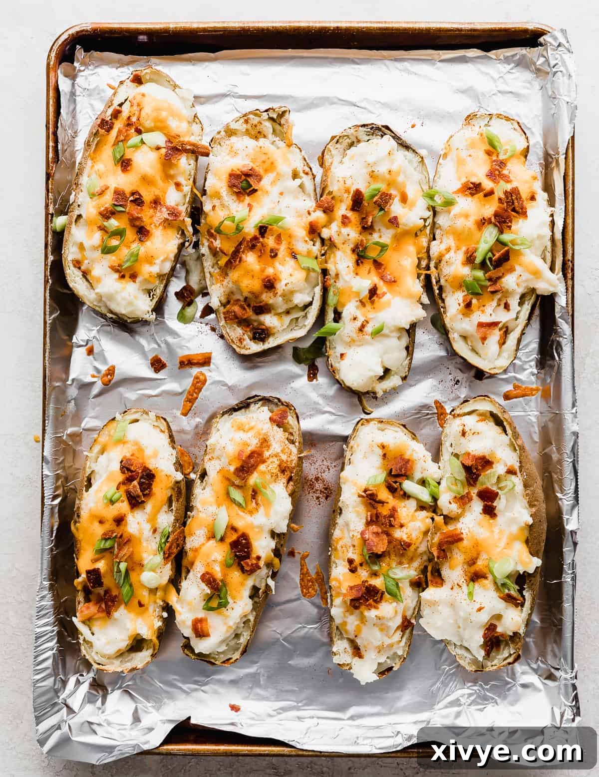 Decadent Double-Baked Potatoes 11 Twice Baked Potatoes with Cream Cheese topped with bacon pieces and sliced green onions.