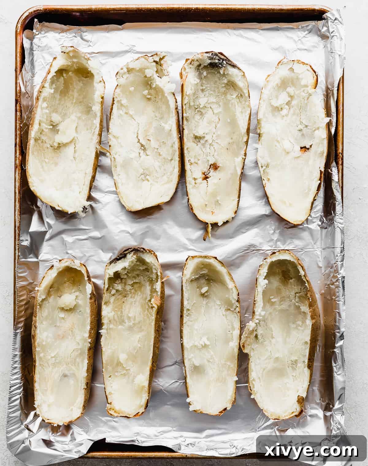 Decadent Double-Baked Potatoes 4 Potato skins on a baking sheet for making Twice Baked Potatoes with Cream Cheese.