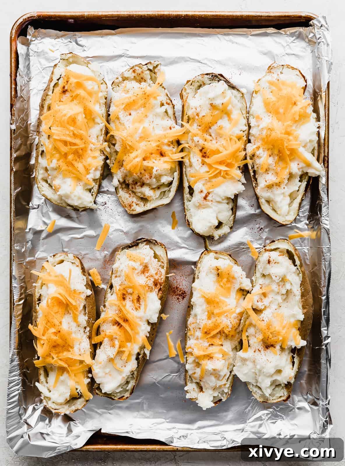Decadent Double-Baked Potatoes 10 Twice Baked Potatoes topped with shredded cheddar cheese.