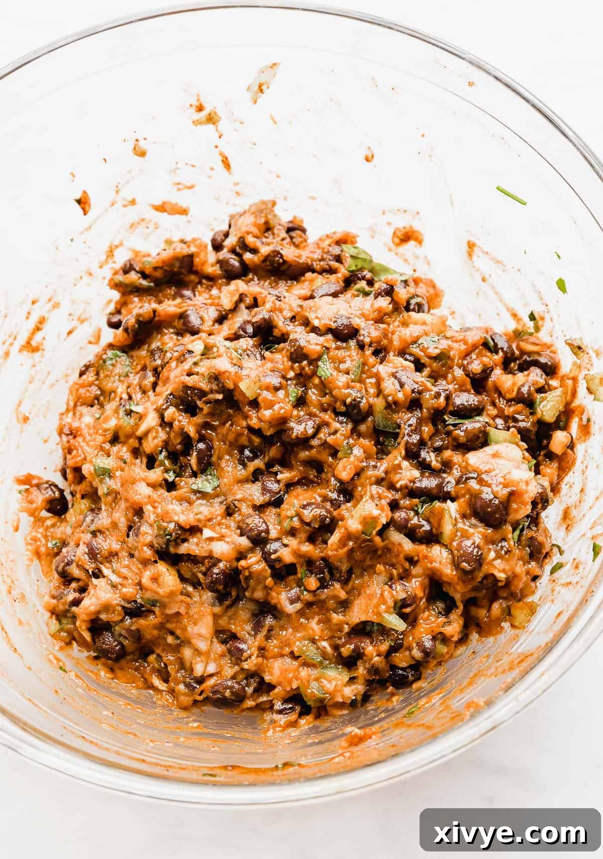 Fiesta Turkey Burgers 5 Raw Taco Turkey Burger mixture with visible black beans and spices in a glass bowl, ready for patty formation.