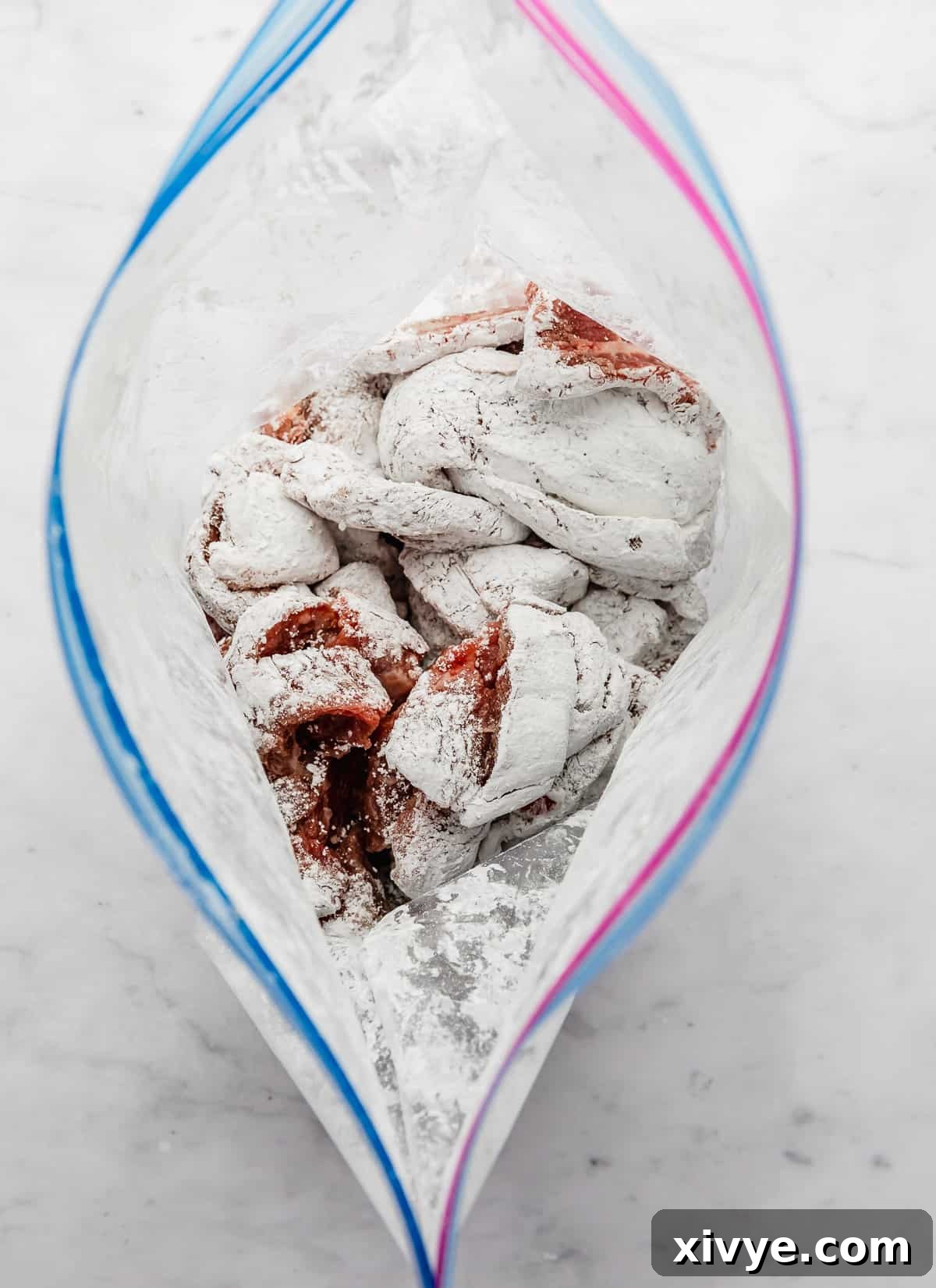 A ziplock bag with cornstarch covered flank steak strips inside, ready to be added to the slow cooker.