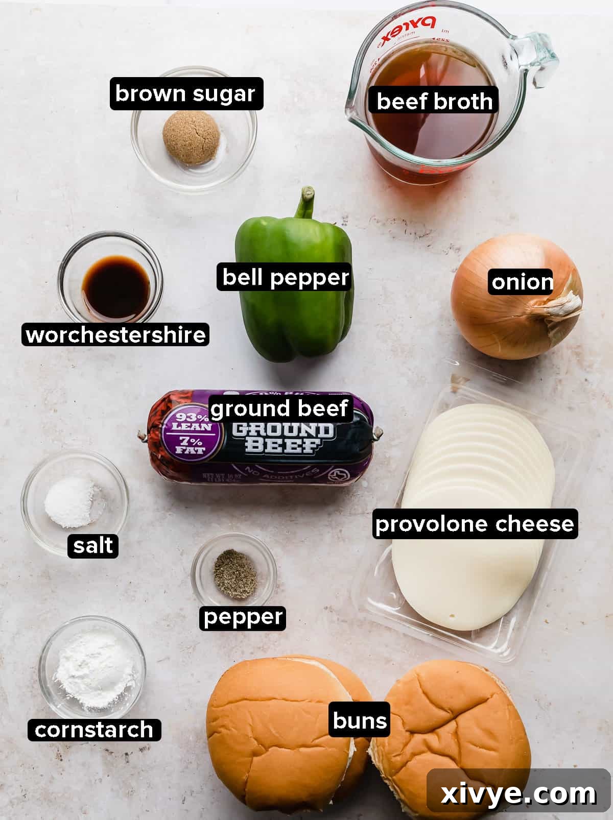 Philly Cheesesteak Joes 3 A vibrant display of fresh ingredients for Philly Cheesesteak Sloppy Joes on a clean white background, showcasing ground beef, bell peppers, onions, and provolone cheese.