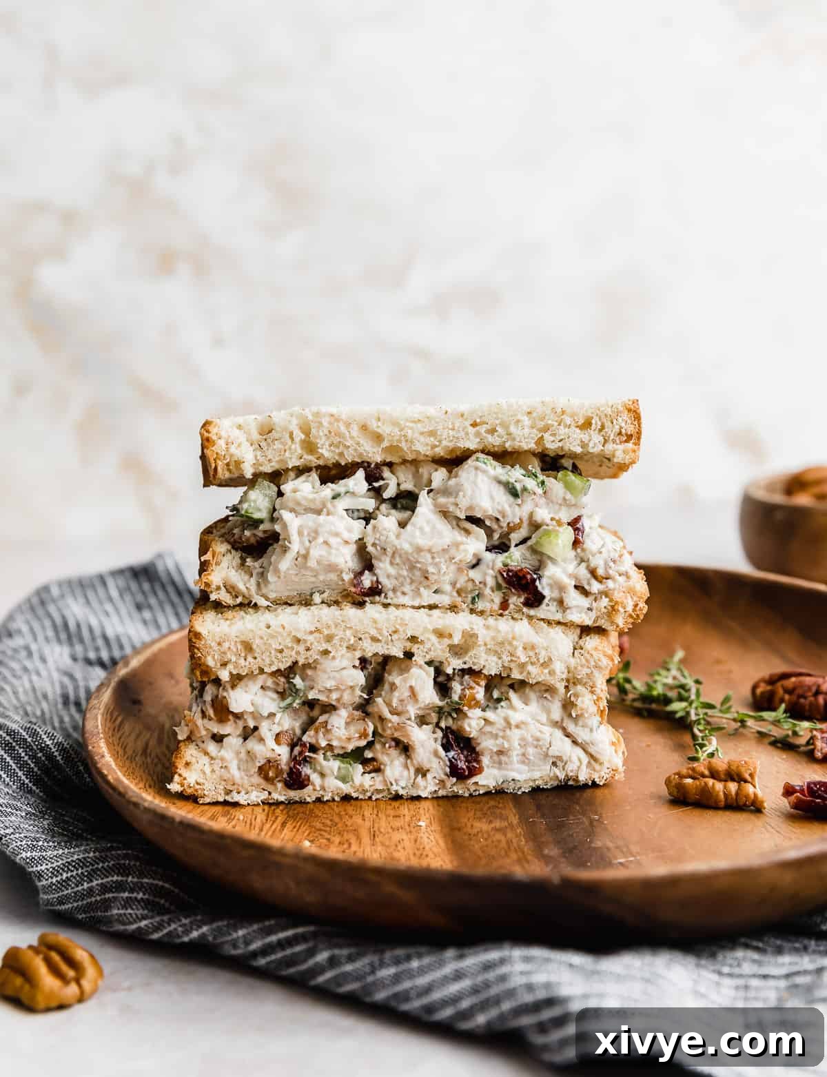 Leftover Turkey Salad on slices of bread that are cut in half, stacked on top of each other on a brown plate.