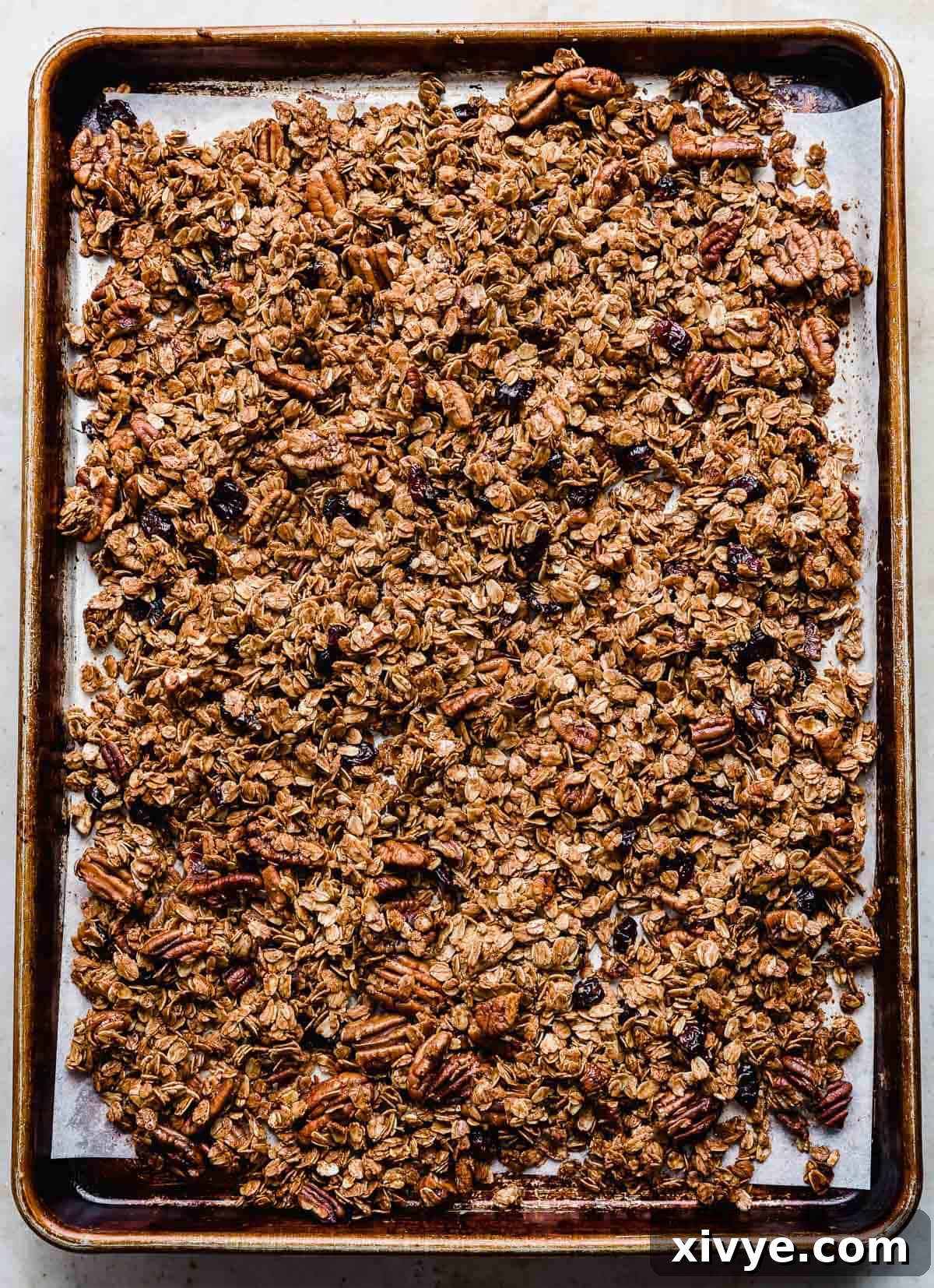 Festive Gingerbread Granola 11 Freshly baked gingerbread granola, golden brown and perfectly crispy, cooling on a baking sheet.