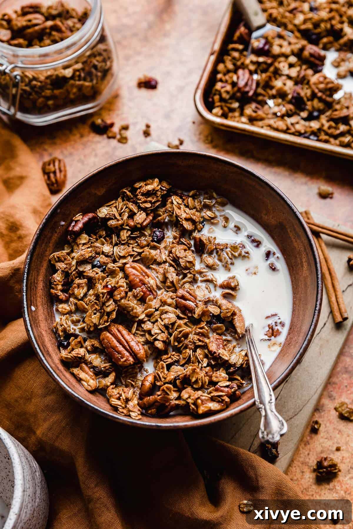Festive Gingerbread Granola 13 A bowl of Gingerbread Granola with milk and a spoon, ready for a festive breakfast.