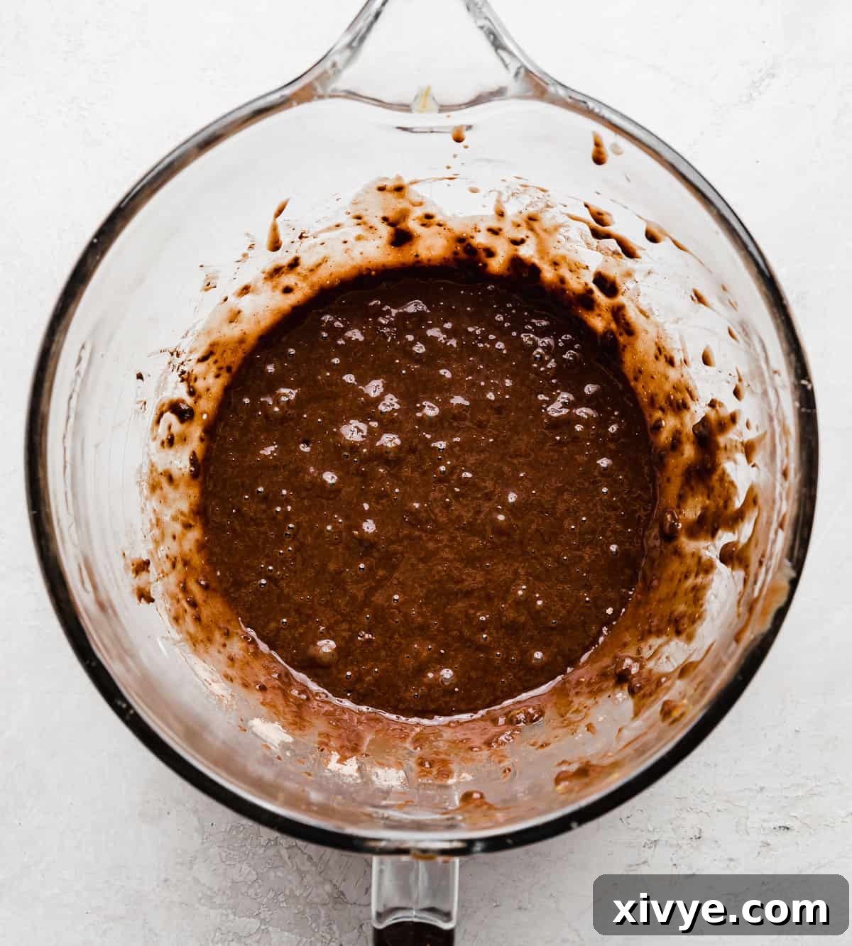 Chocolate Orange Cupcake batter in a glass bowl on a light gray background.