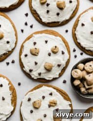 Crumbl Cookie Dough Dream 13 Crumbl Cookie Dough Cookies topped with white ice cream flavored frosting, mini chocolate chips, and edible cookie dough bites.