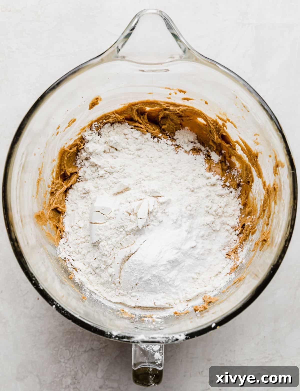 Crumbl Cookie Dough Dream 5 A white flour mixture on top of a deep brown colored creamed butter and sugar mixture.