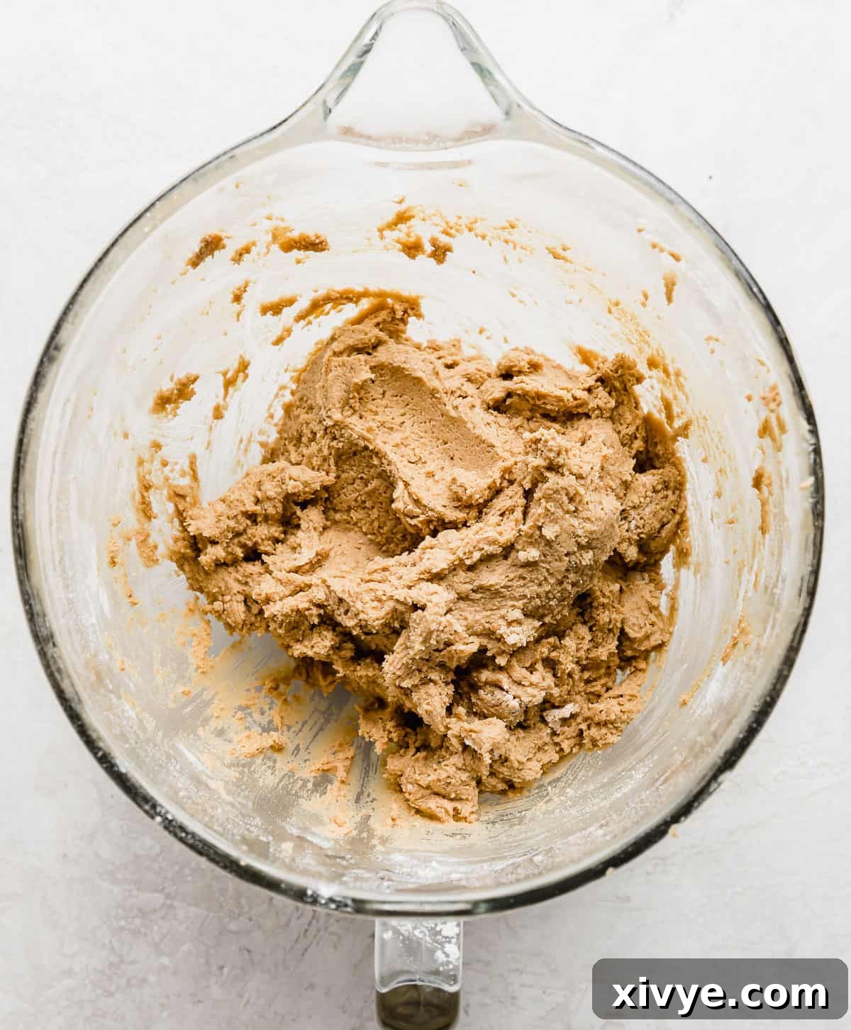 Crumbl Cookie Dough Dream 6 Crumbl Cookie Dough Cookie dough (medium brown in color) in a glass mixing bowl.