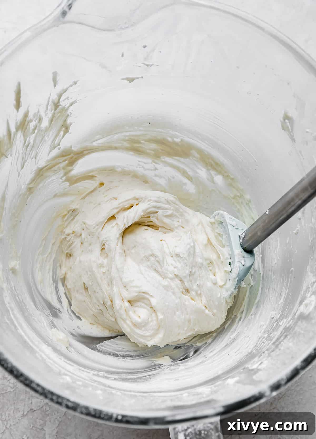 Crumbl Cookie Dough Dream 10 White frosting in a glass mixing bowl.