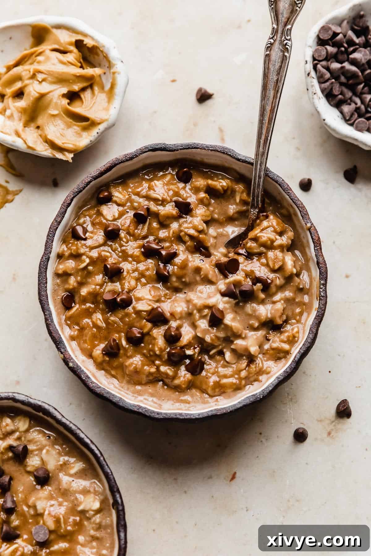 A black bowl full of Chocolate Peanut Butter Protein Oatmeal topped with mini chocolate chips.