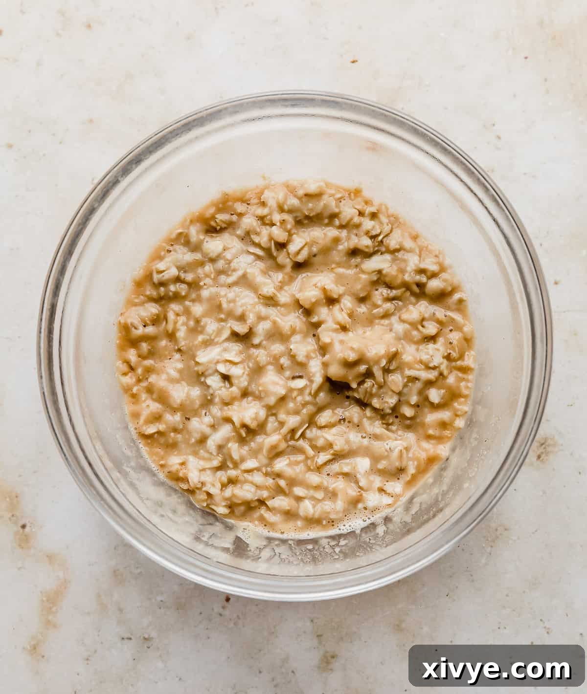 A glass bowl with peanut butter oatmeal in it.