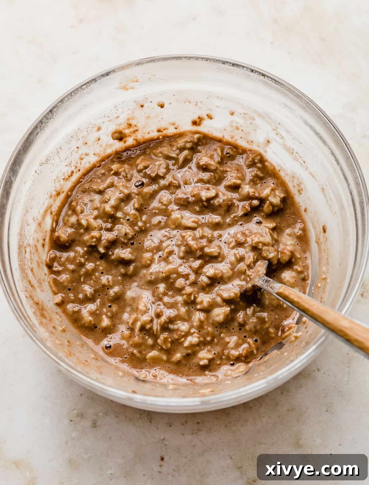 Chocolate Peanut Butter Protein Oatmeal in a glass bowl on a cream colored marble background.