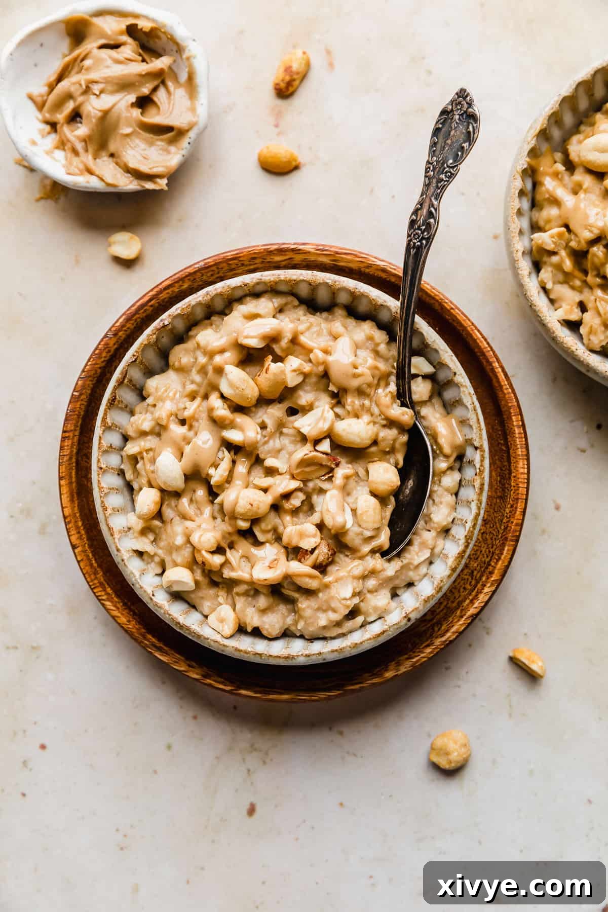 Peanut Butter Oatmeal in a ceramic bowl topped with drizzled peanut butter and chopped peanuts.