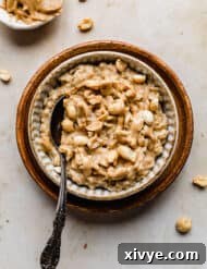 Peanut Butter Oatmeal in a bowl on a tan marble background.
