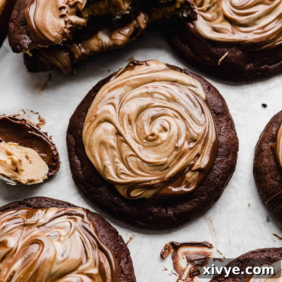 A decadent brownie cookie topped with melted chocolate and peanut butter that has been swirled together.